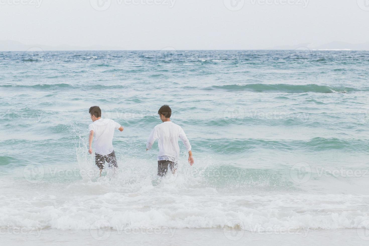 Homosexual portrait young asian couple running with cheerful together on beach in summer, asia gay going tourism for leisure and relax with happiness in vacation at sea, LGBT legal concept. photo