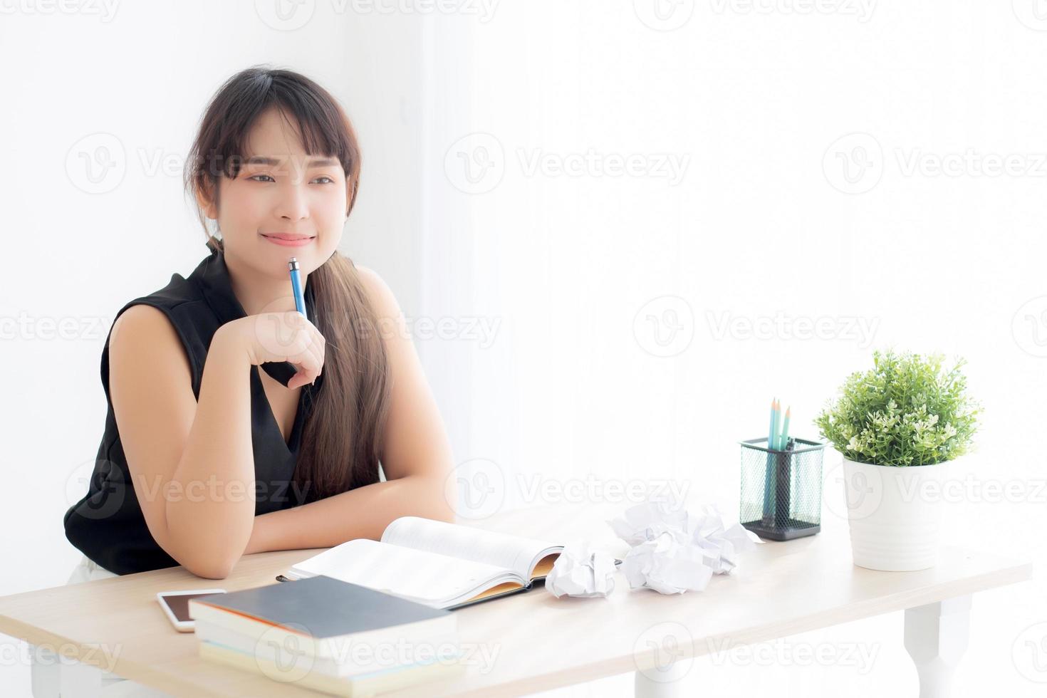 Beautiful asian woman writer smiling thinking idea writing on notebook diary with planning working on desk office, lifestyle asia girl have inspiration with success, education and business concept. photo