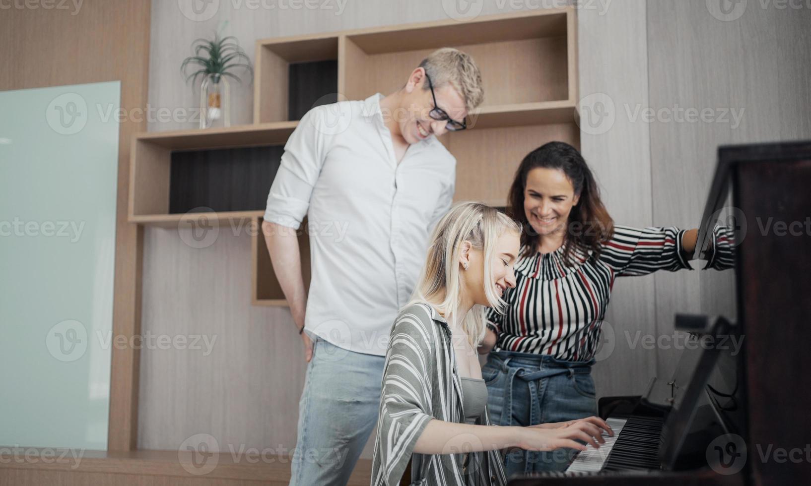 familia feliz, madre, padre e hija tocando el piano en casa, concepto de relación familiar. foto