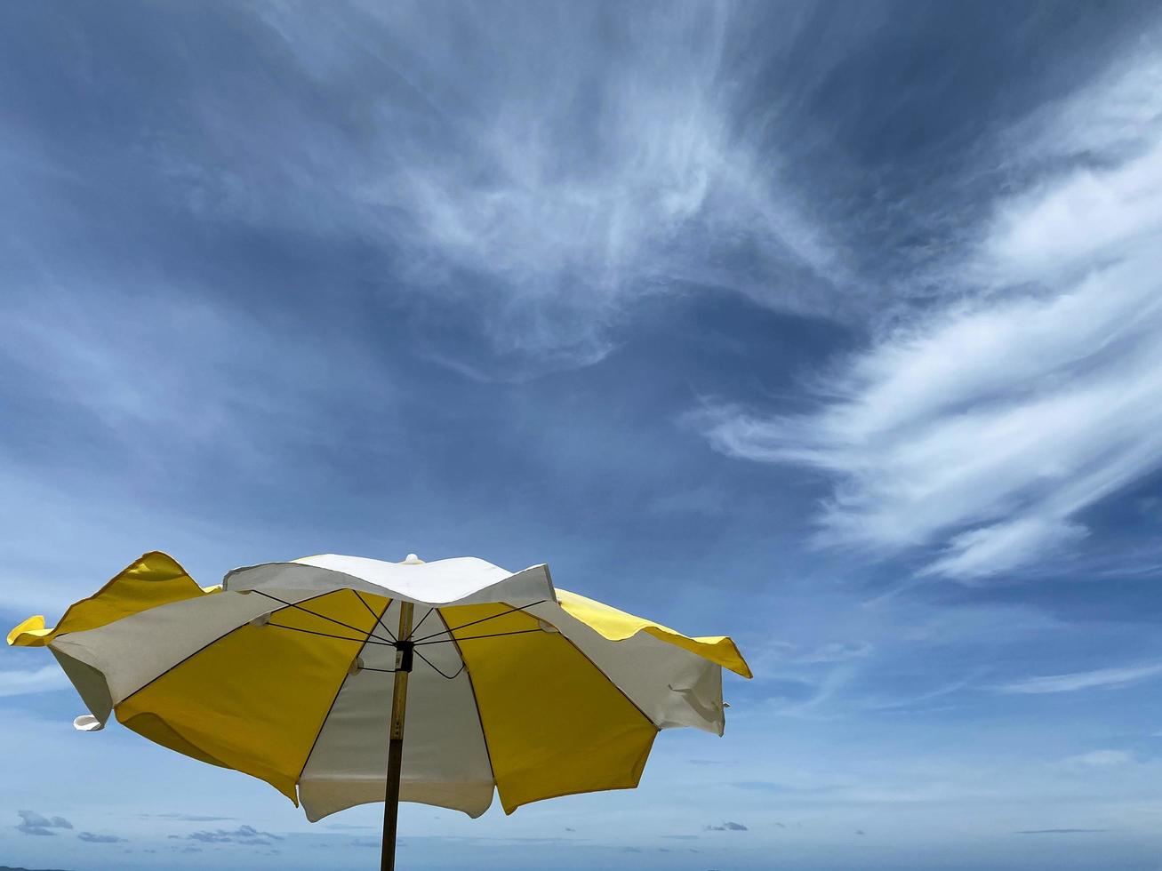 Yellow umbrella on summer sky photo