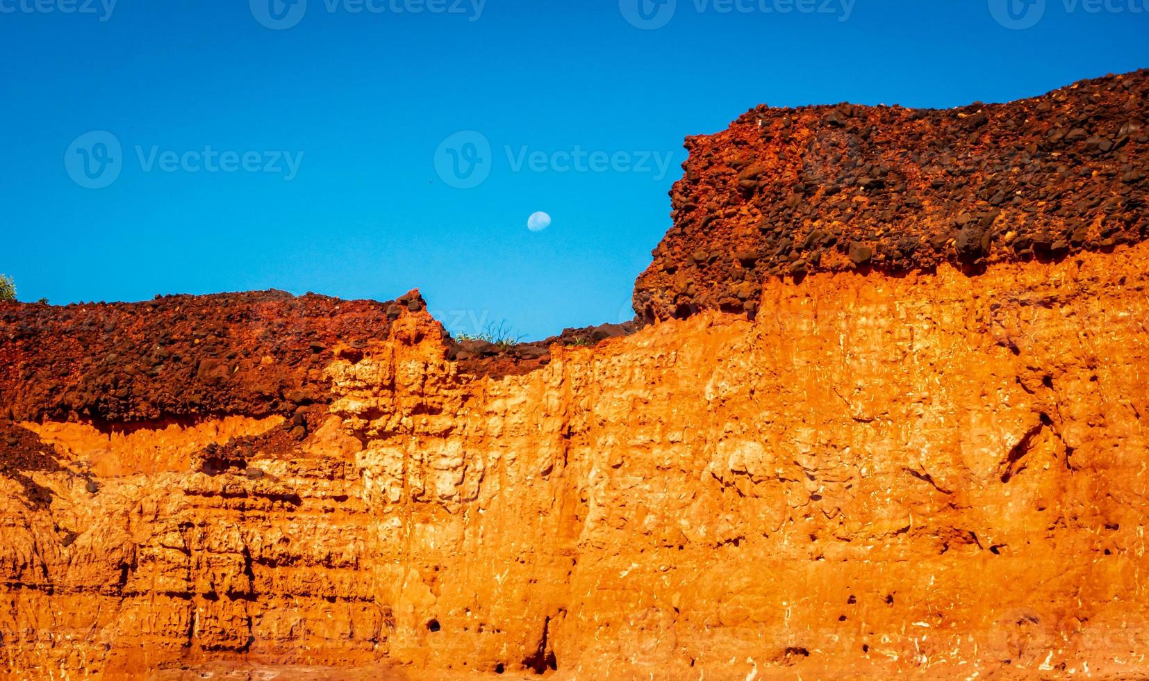 Moon rising over red cliffs photo