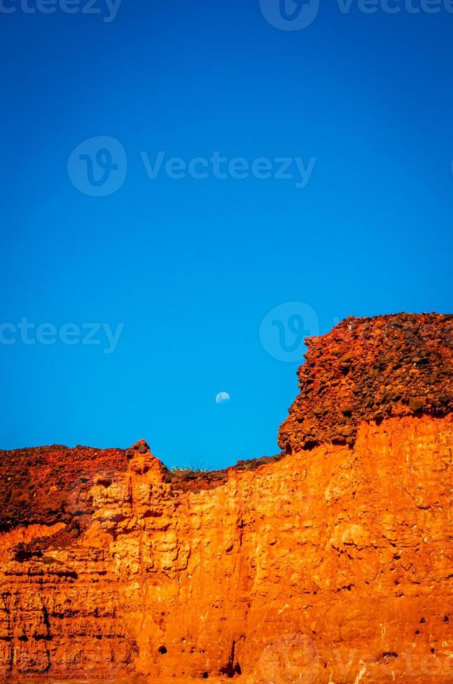 Moon rising over red cliffs photo