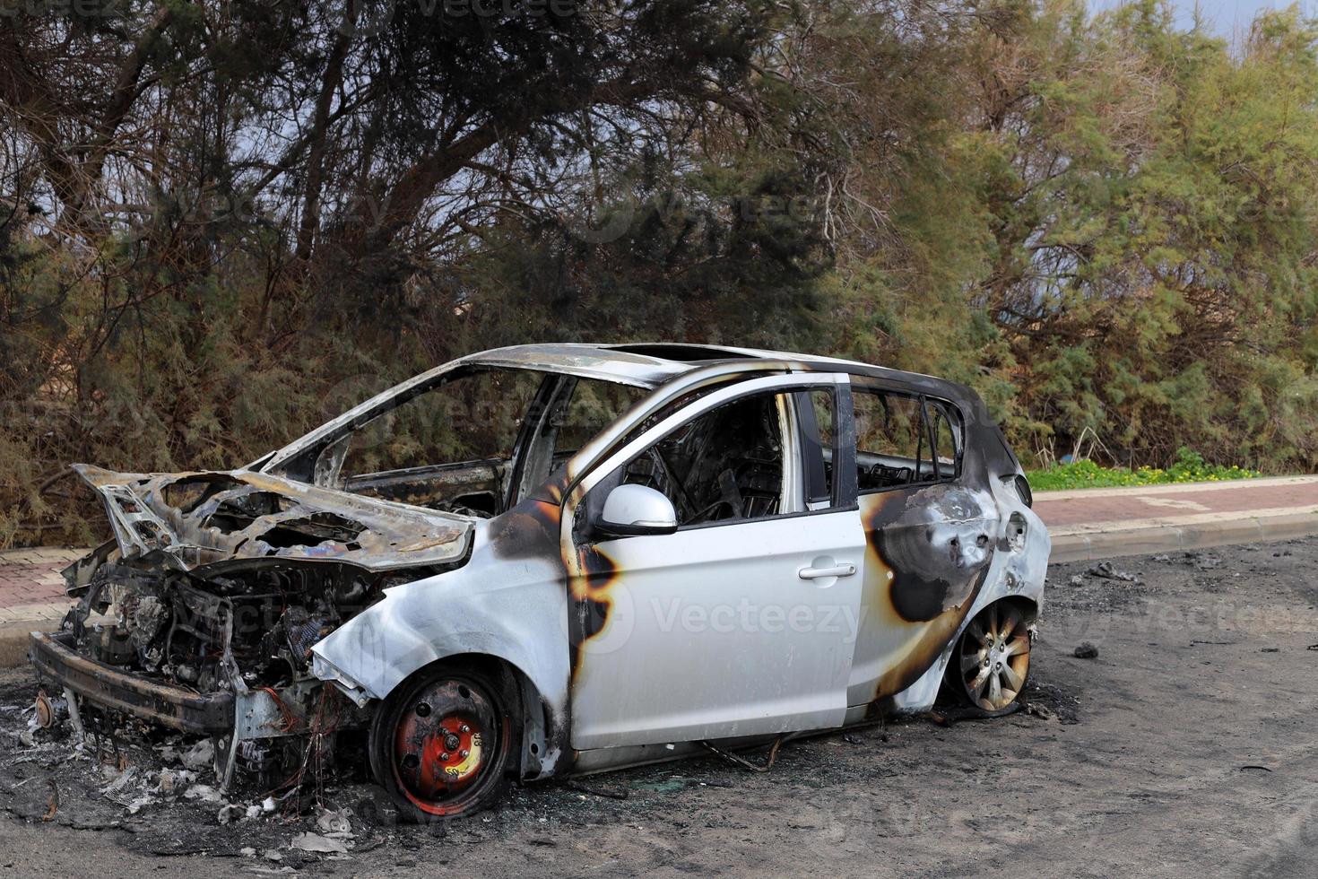 Burnt out car on the road photo