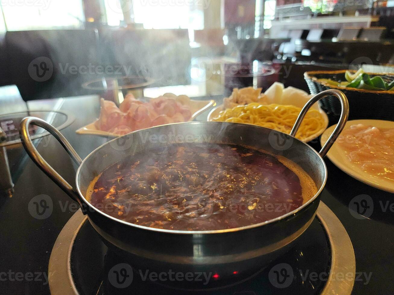 Chinese hot pot with spicy broth in bowl on table photo