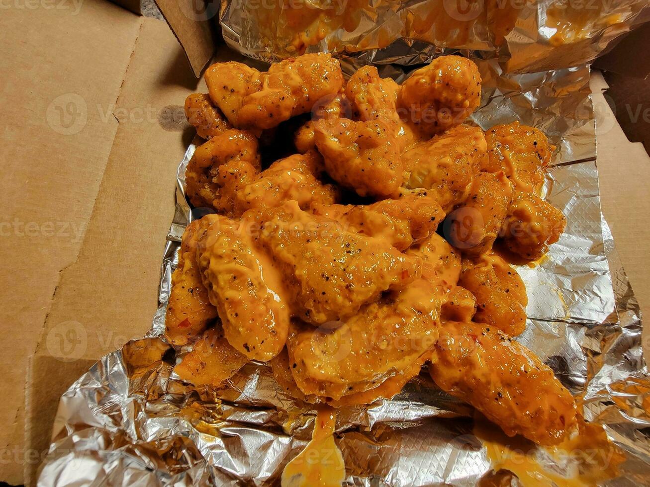 pile of boneless chicken wings with spicy sauce photo
