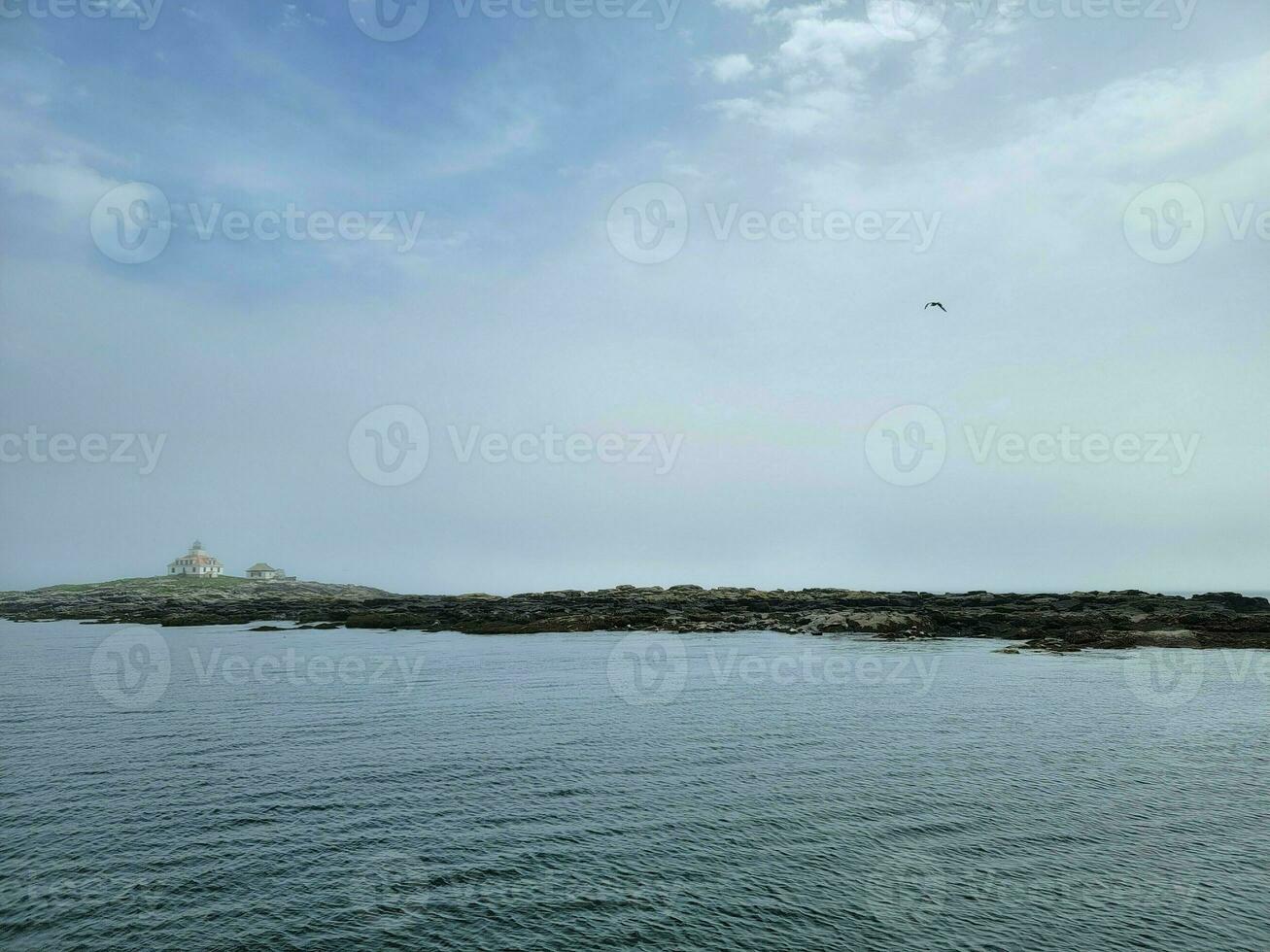 lighthouse and rocky shore on the coast of Maine photo