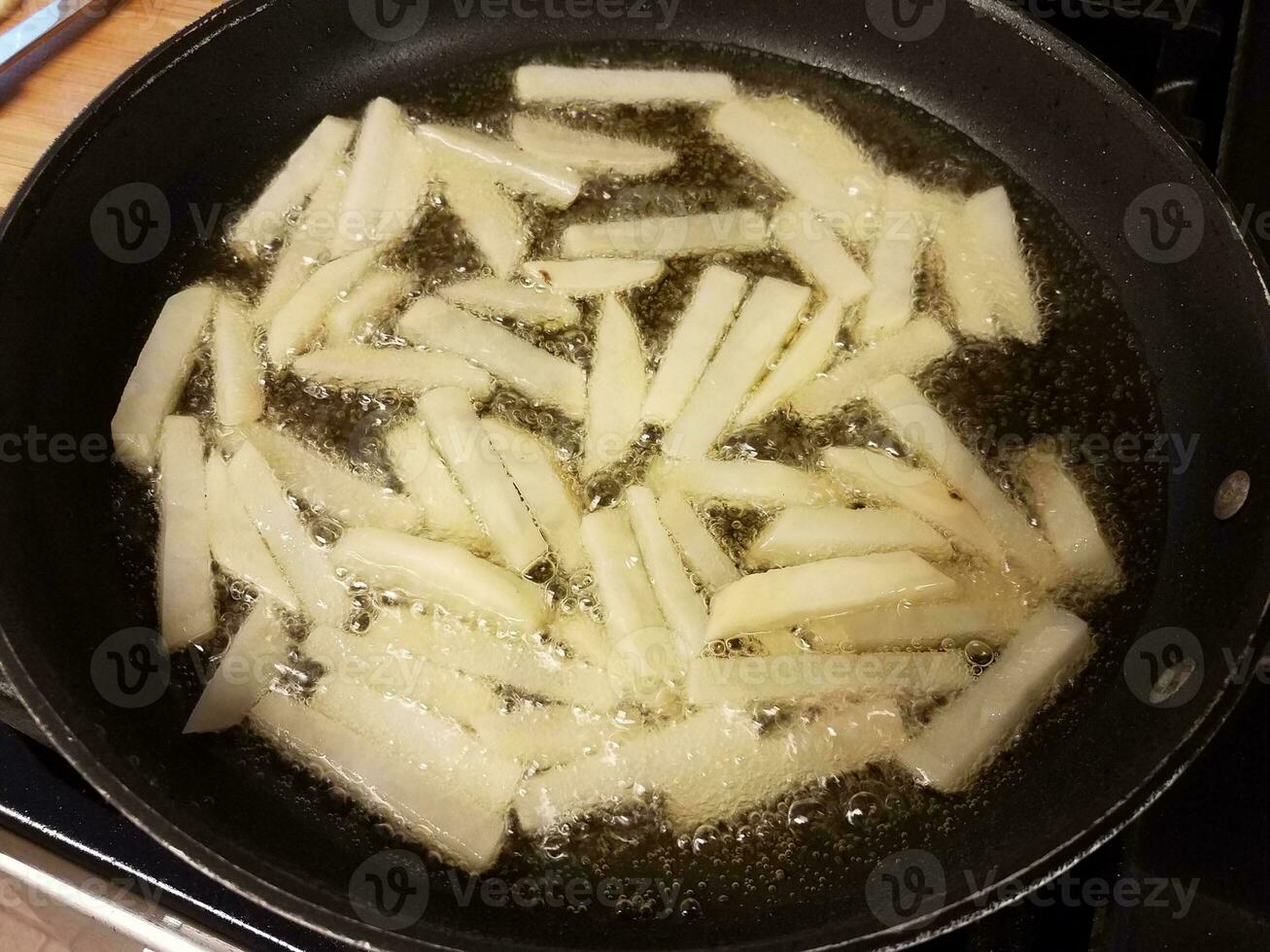 potato fries cooking in hot oil in skillet photo