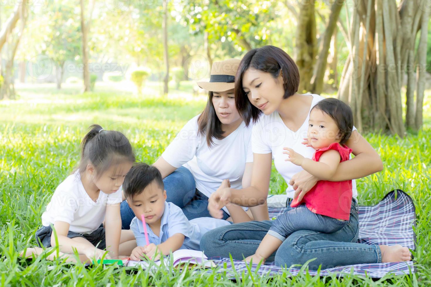 Beautiful young asian parent family portrait picnic in the park, kid or children and mother love happy and cheerful together in summer at garden, lifestyle concept. photo