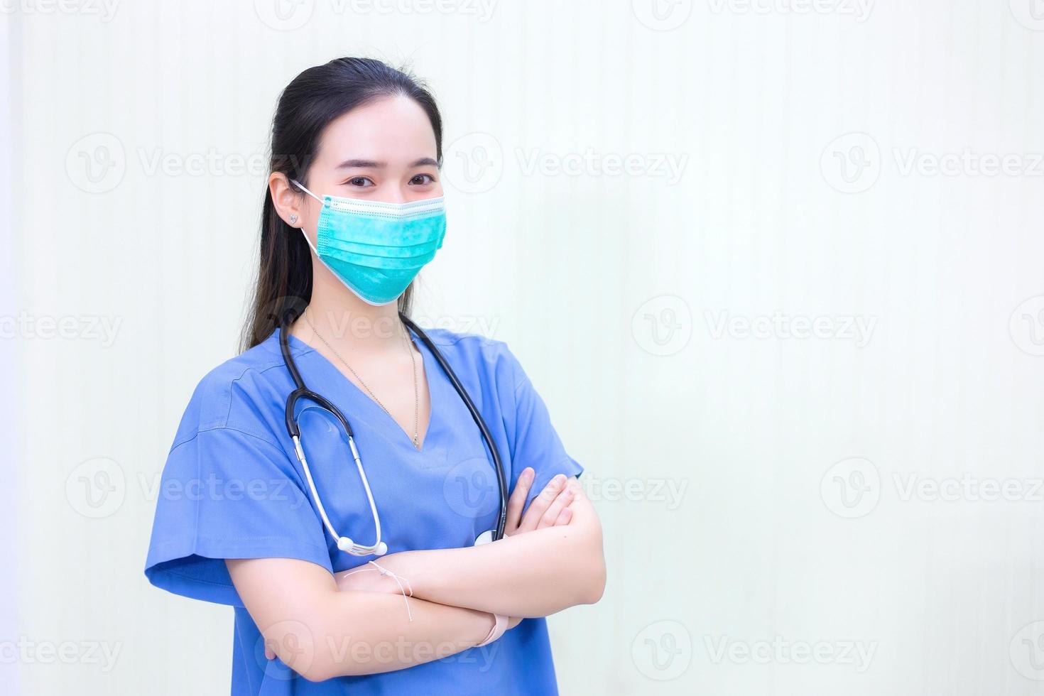 Asian doctor wears a medical coat with stethoscope  and medical face mask to protect respiratory system from pathogen in new normal concept. photo