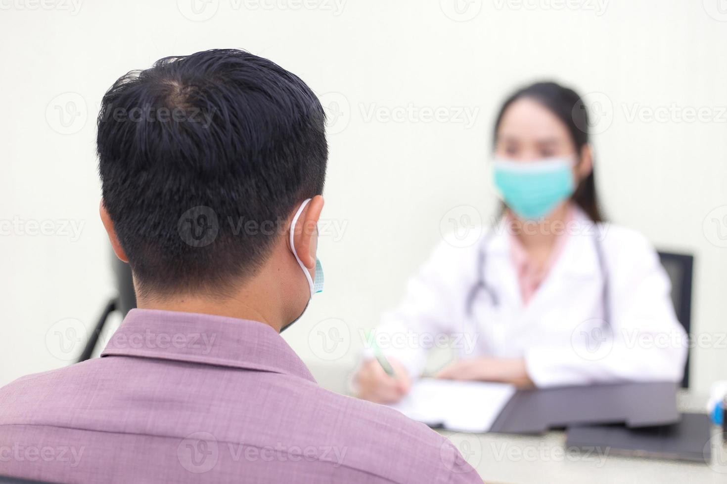 Asian man patient consults with a woman doctor about his health and symptom photo