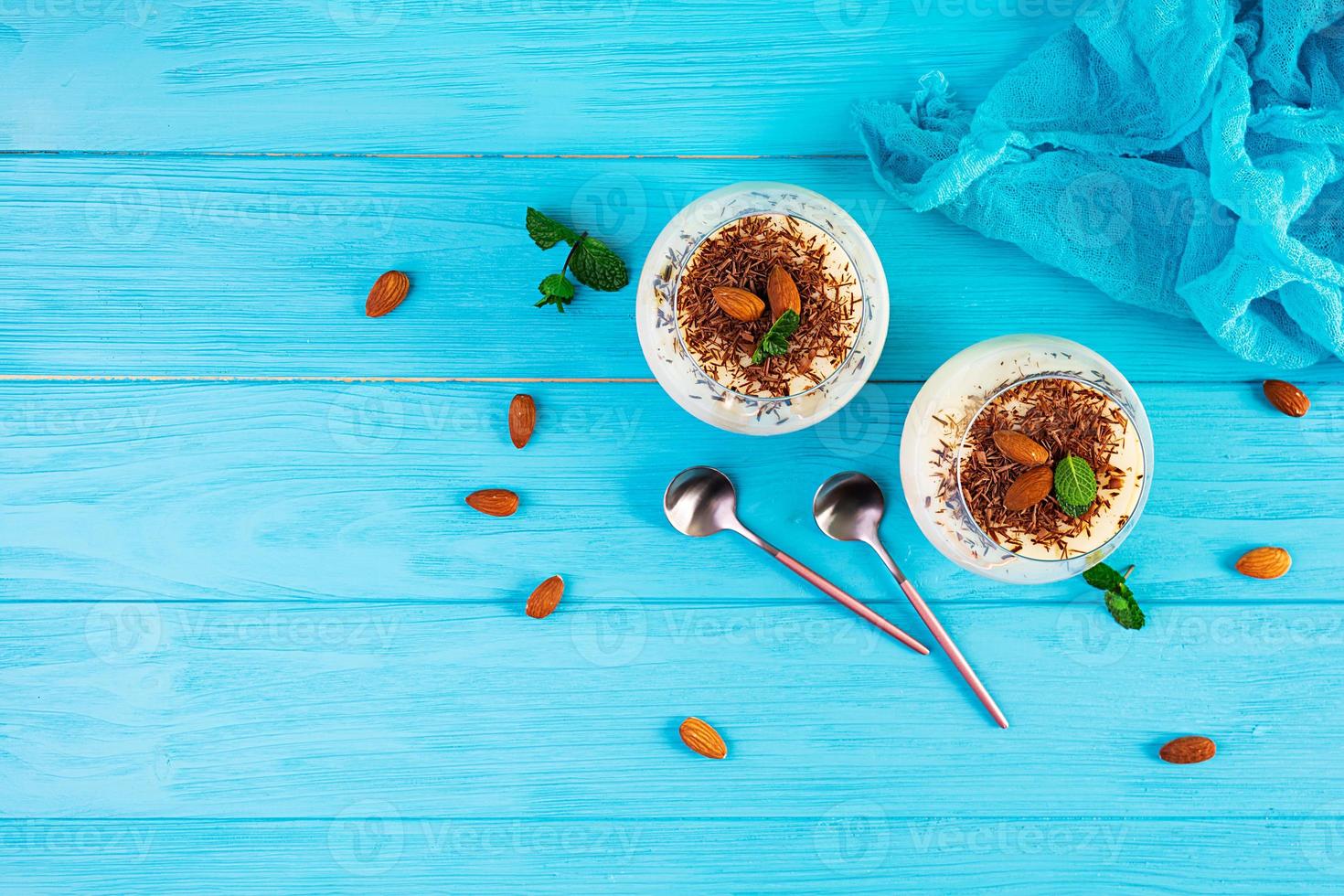 pudín de leche dulce con almendras y chispas de chocolate sobre fondo azul foto