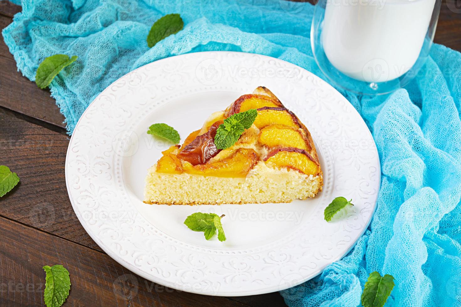 Delicious homemade peach pie on wooden background photo