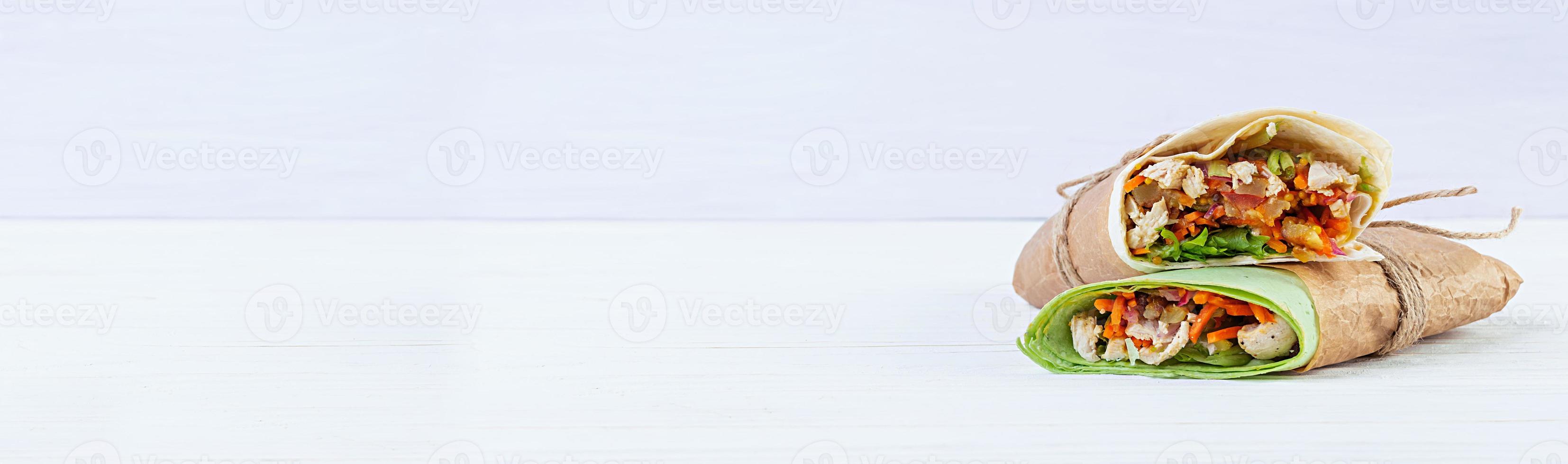 Delicious shawarma sandwich with chicken on wooden background photo