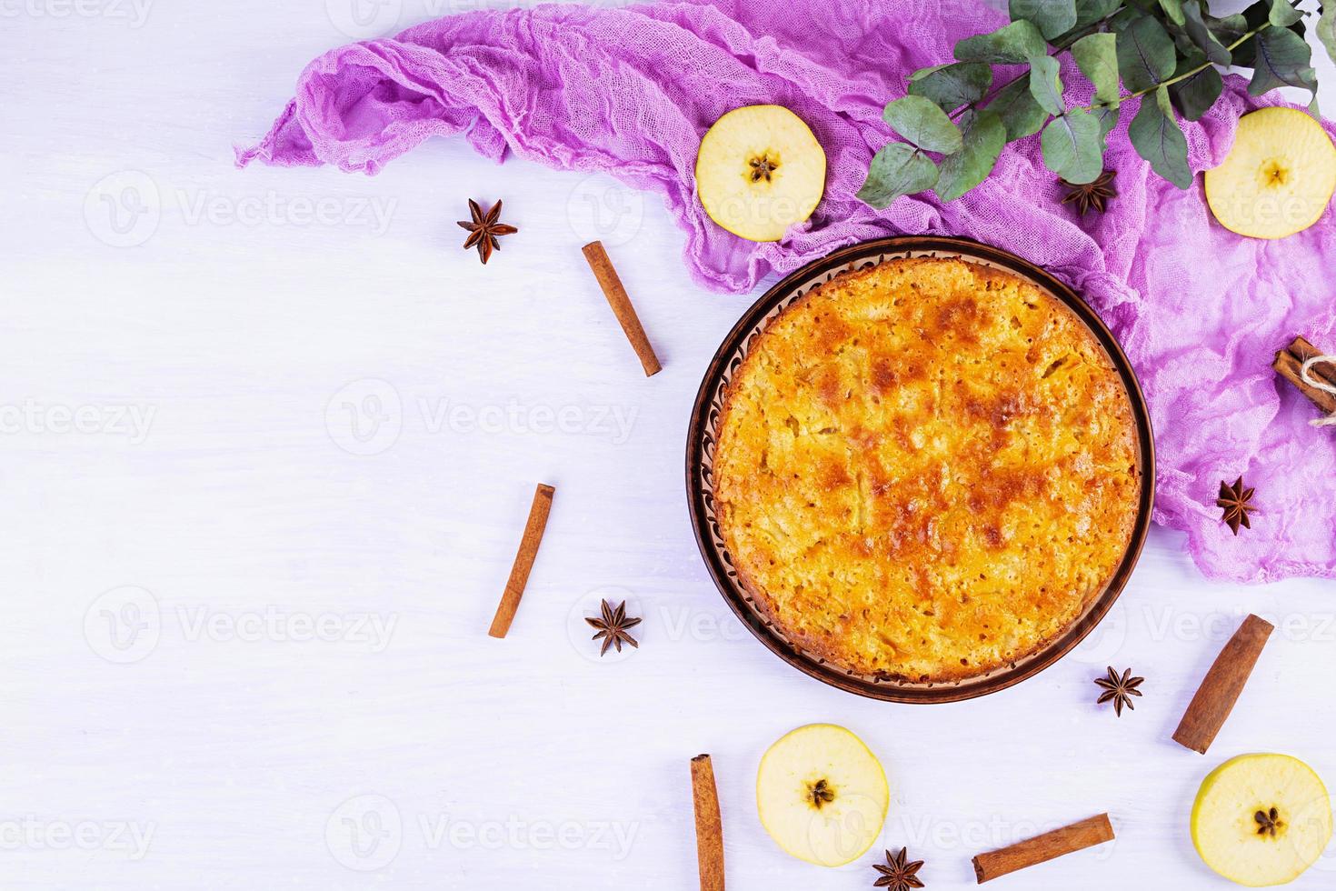 delicioso pastel de manzana casero sobre fondo rosa. pastel de manzana con ingredientes, manzanas y canela. vista superior foto