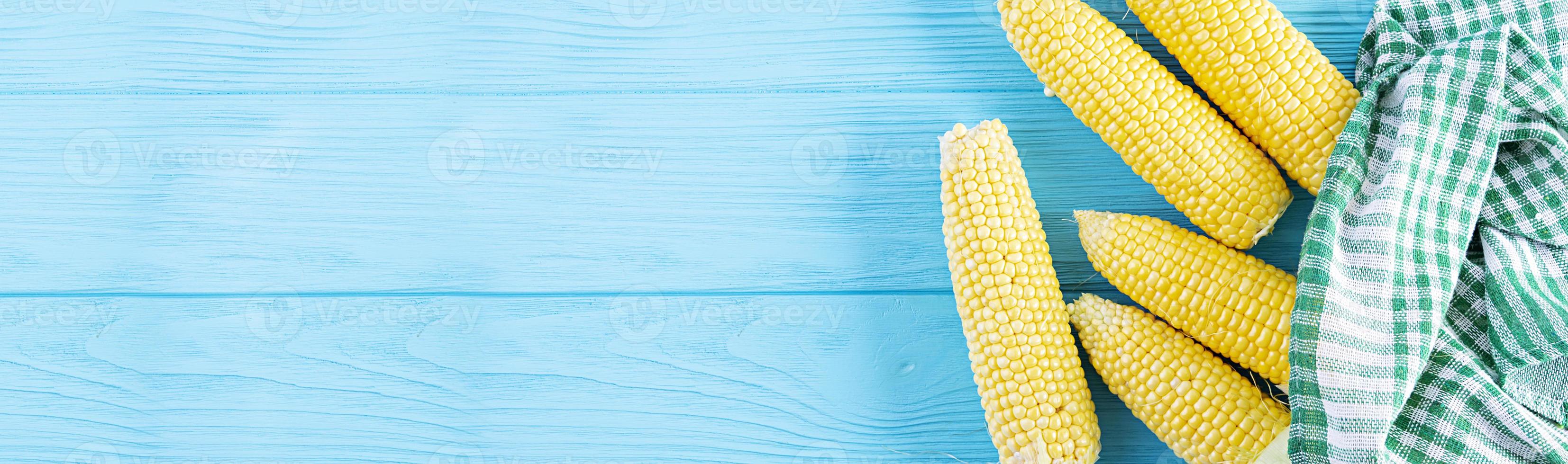 Fresh juicy corn isolated on wooden background. Grain crops concept photo