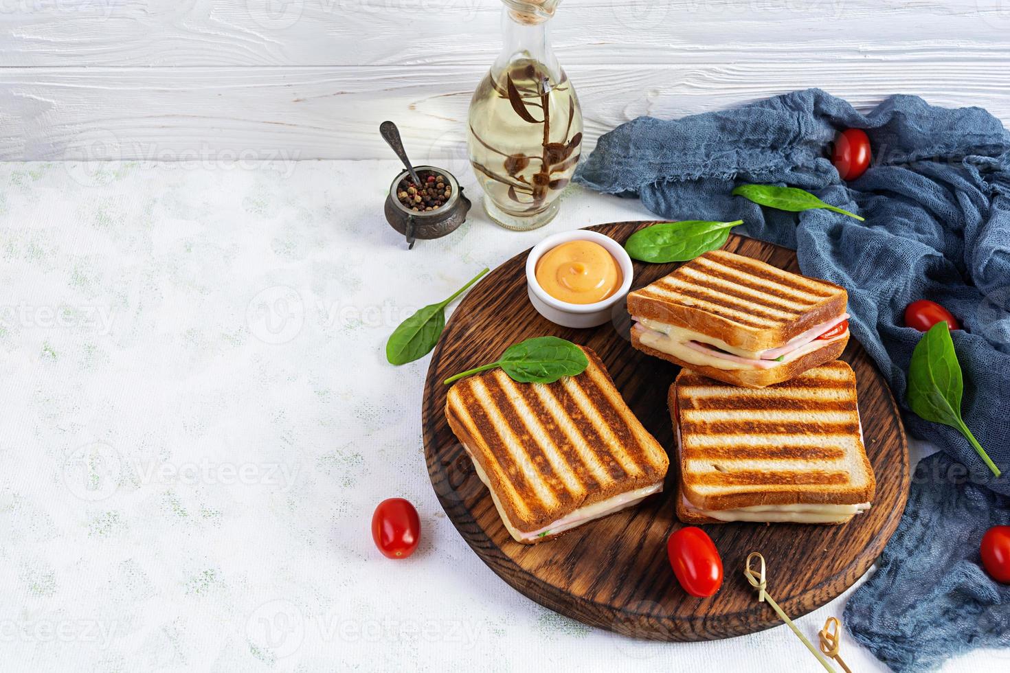 Club sandwich with ham, tomato, cheese and spinach. Grilled panini photo