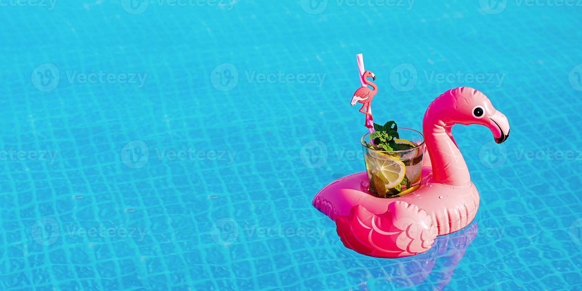 Fresh coctail mojito on inflatable pink flamingo toy at swimming pool. Vacation concept. photo