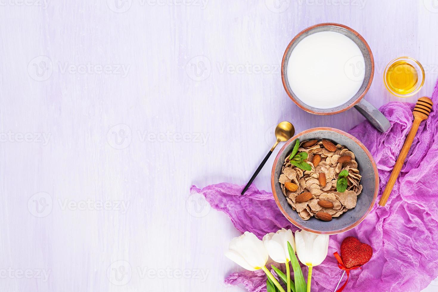 copos de espelta con leche en el desayuno. desayuno ligero en el día de san valentín con tulipanes y corazón foto