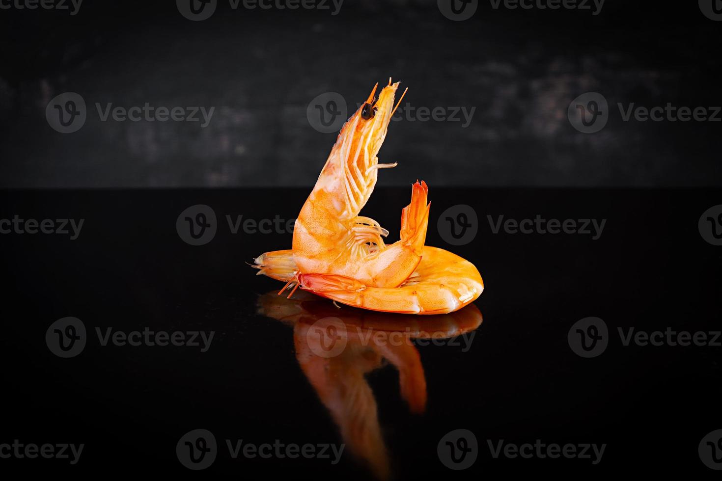 Delicious cooked shrimps isolated on dark background. Boiled prawns photo