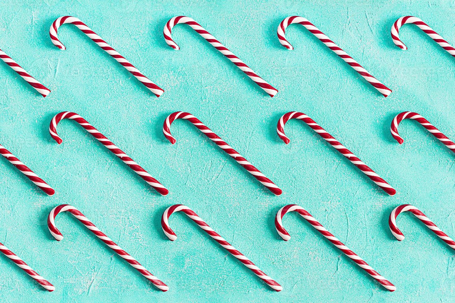 Christmas striped candy cane isolated on blue background. Candy cane pattern. Top view photo