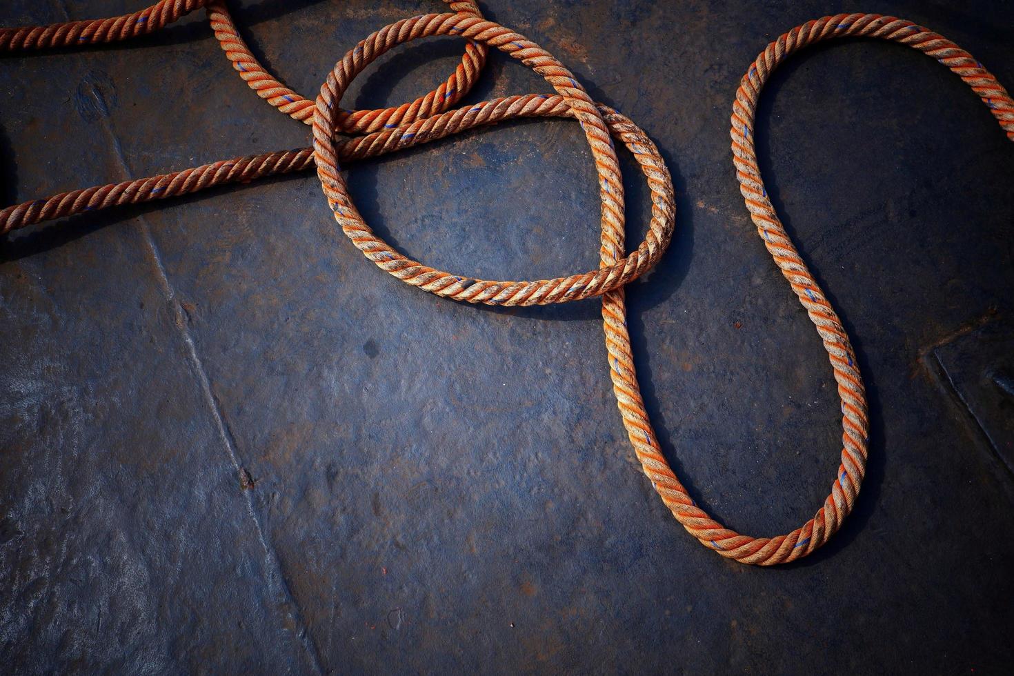 High angle view of the old giant fiber naytical rope on steel boat floor background in dark tone style photo