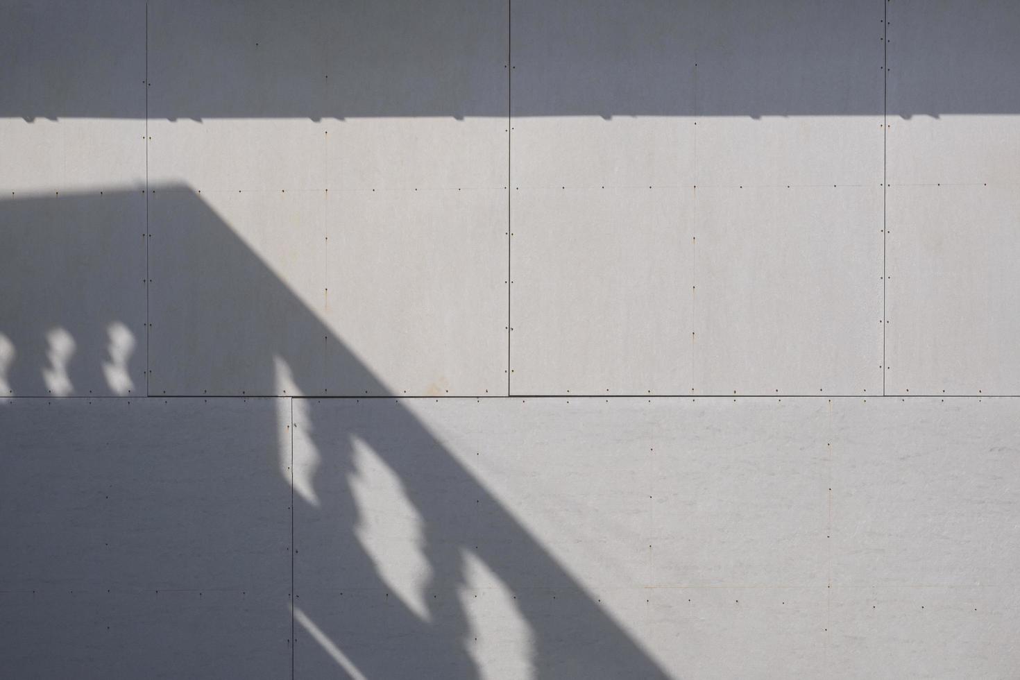 Sunlight and balcony shadow on surface of gray gypsum wall background photo