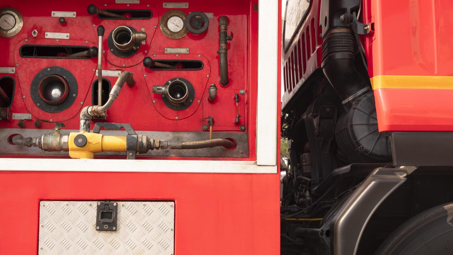 Gauge pressure and valve lever with high pressure fire safety pump on side view of red fire truck photo