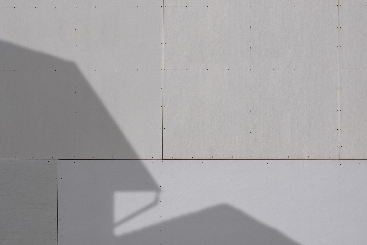 Sunlight and shadow of house structure on gray gypsum wall surface photo