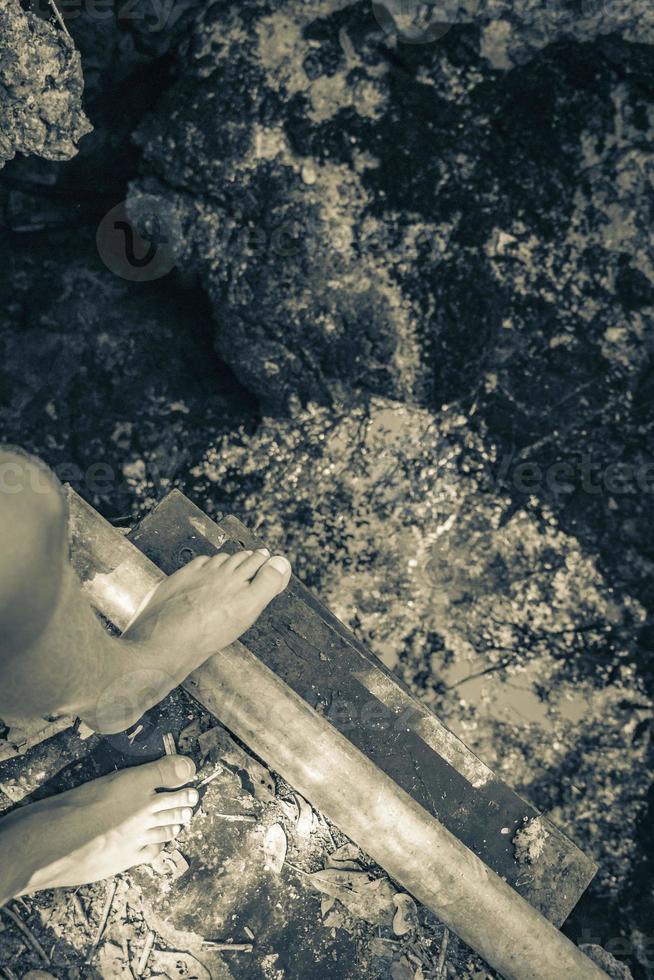 Feet at blue turquoise water limestone cave sinkhole cenote Mexico. photo