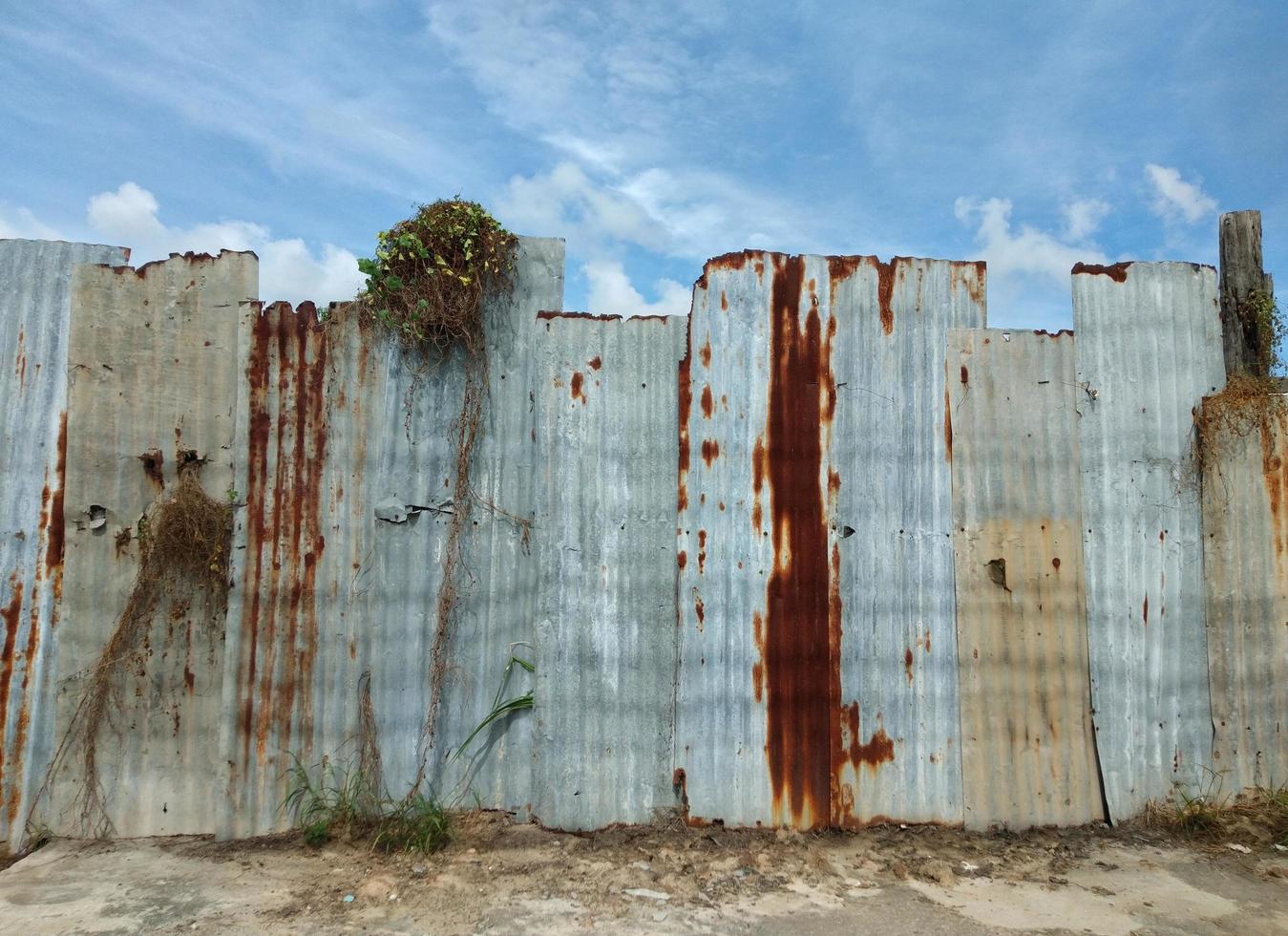 pared de zinc, gris, óxido amarillo, cielo azul con nubes blancas. foto