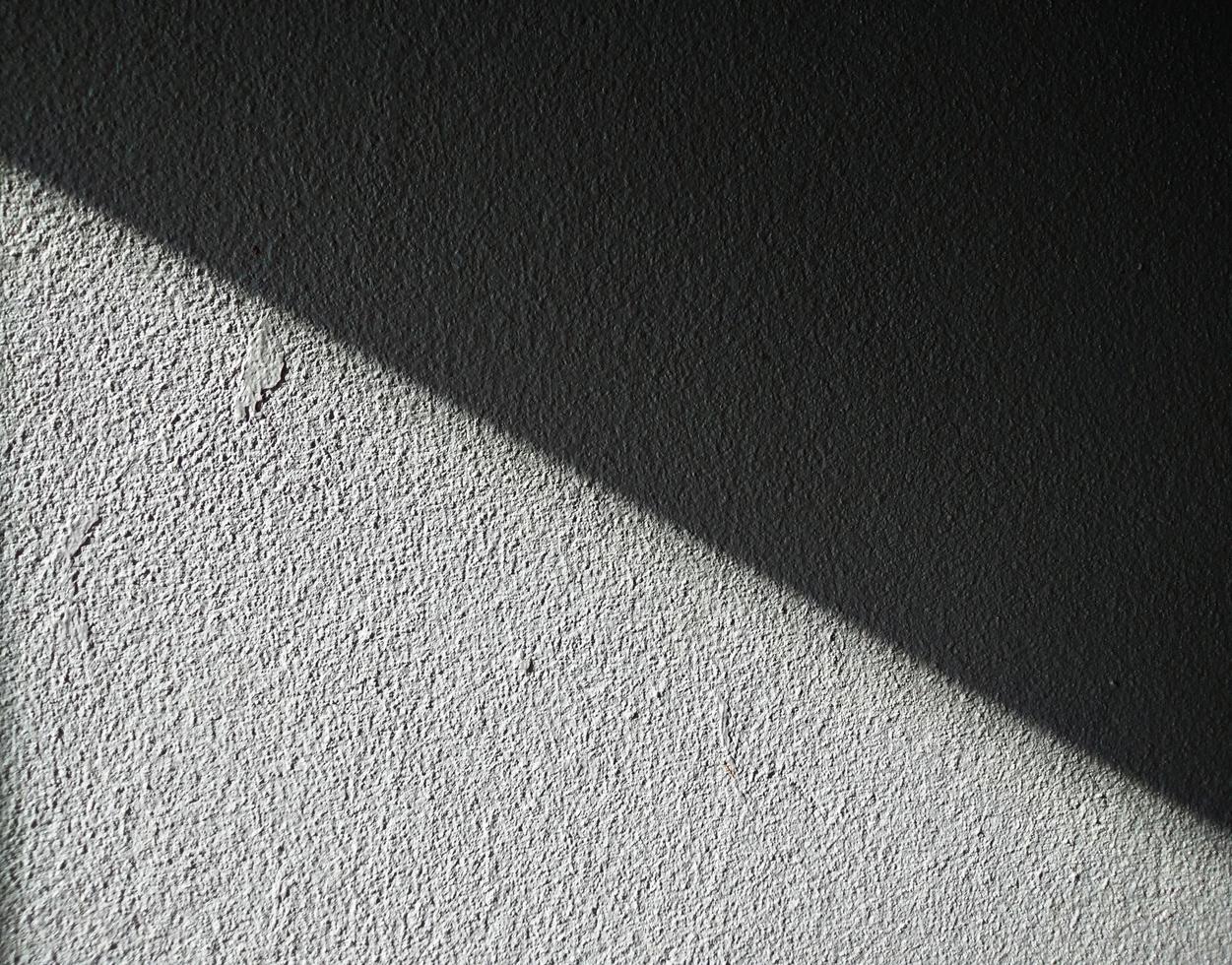 White concrete wall background with black shadows running in straight lines. Two-tone style. Backgrounds and wallpapers photo