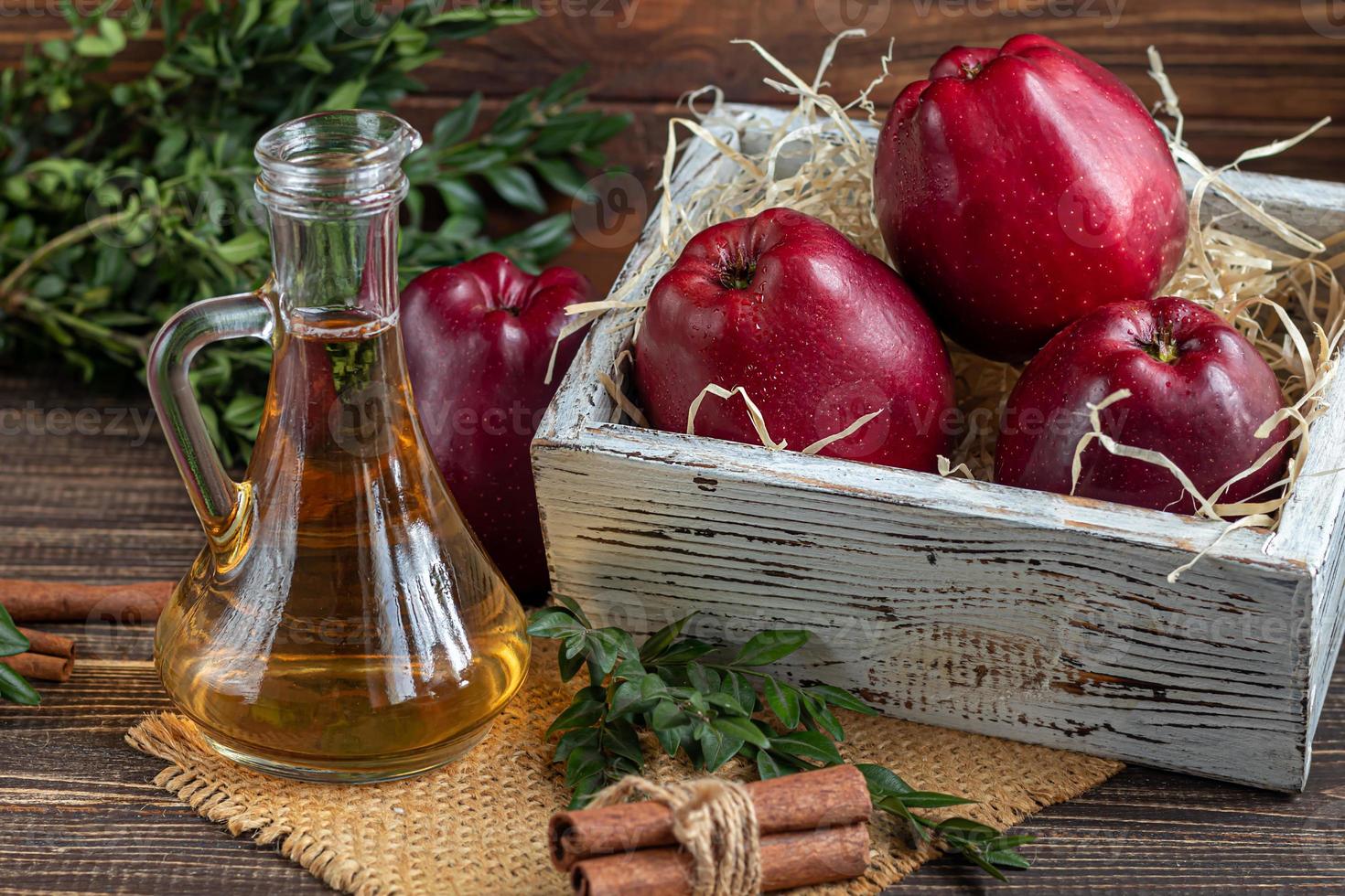 Apple cider vinegar and red apples on a dark, wooden background. Selective focus. fermented product. Healthy food. photo