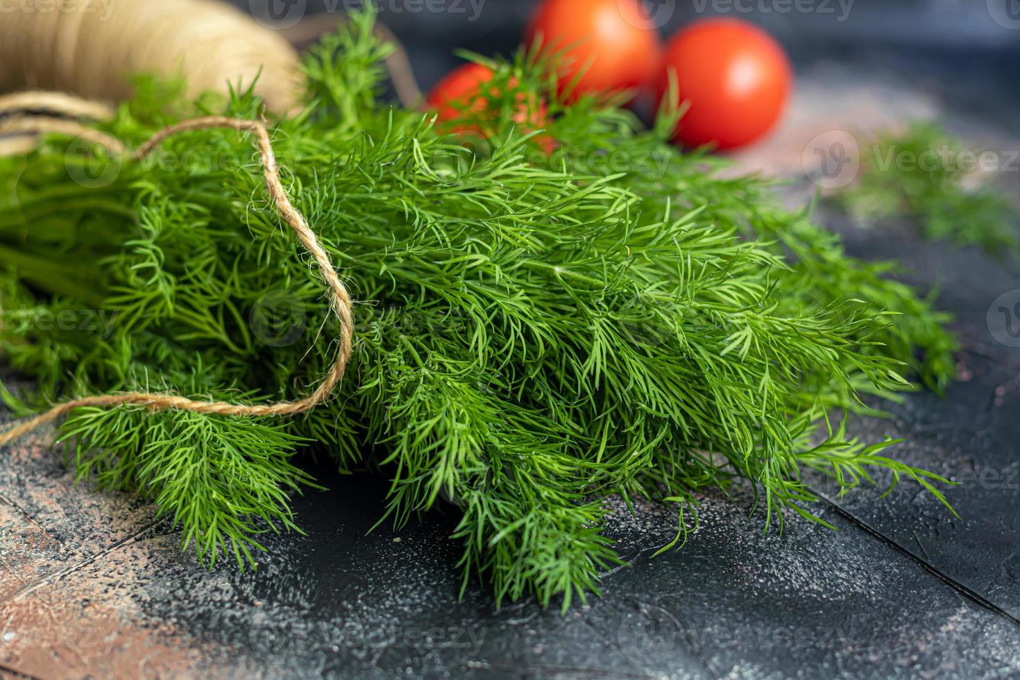 Fresh vegetables for salad. Tomatoes and lettuce, cucumbers with zucchini and cabbage with dill. Spring harvest, benefits and vitamins. On a dark background. photo