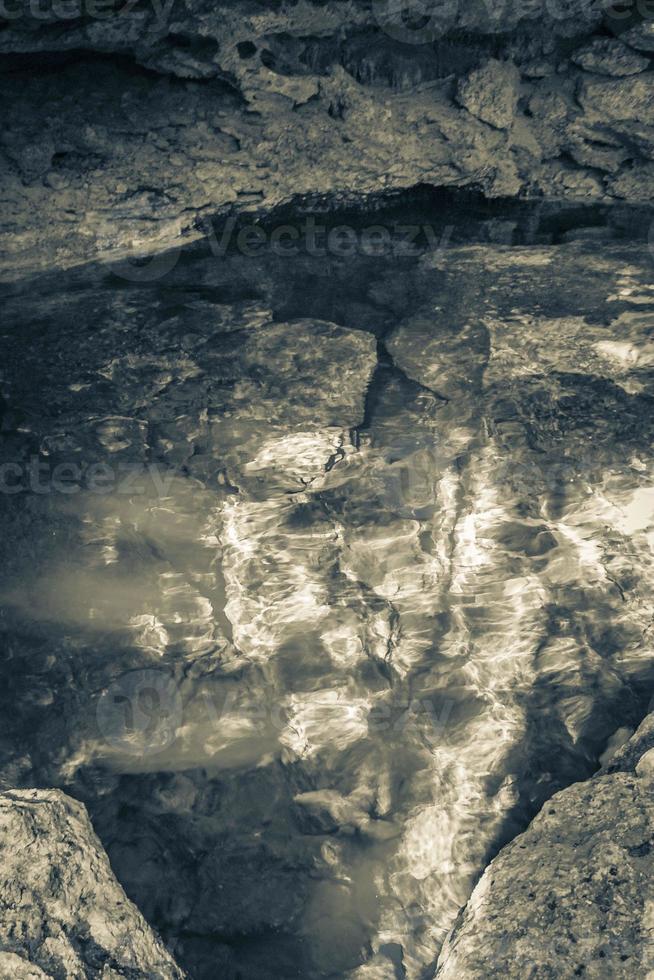 Blue turquoise water limestone cave sinkhole cenote Tajma ha Mexico. photo