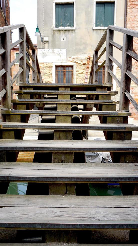 puente de escalera de madera canal cruzado en venecia, italia foto
