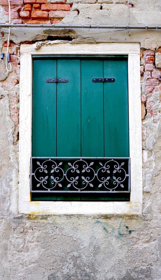 ventana verde en la pared de ladrillo vieja foto