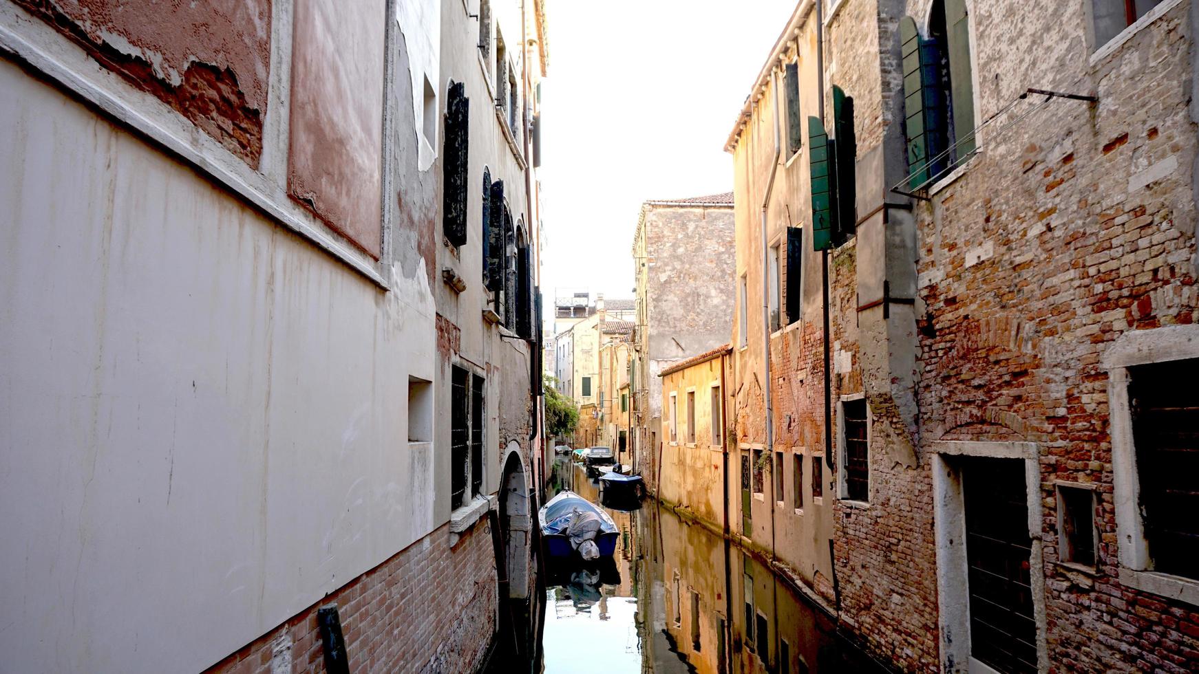 Alley and canal with ancient architecture in Venice, Italy photo