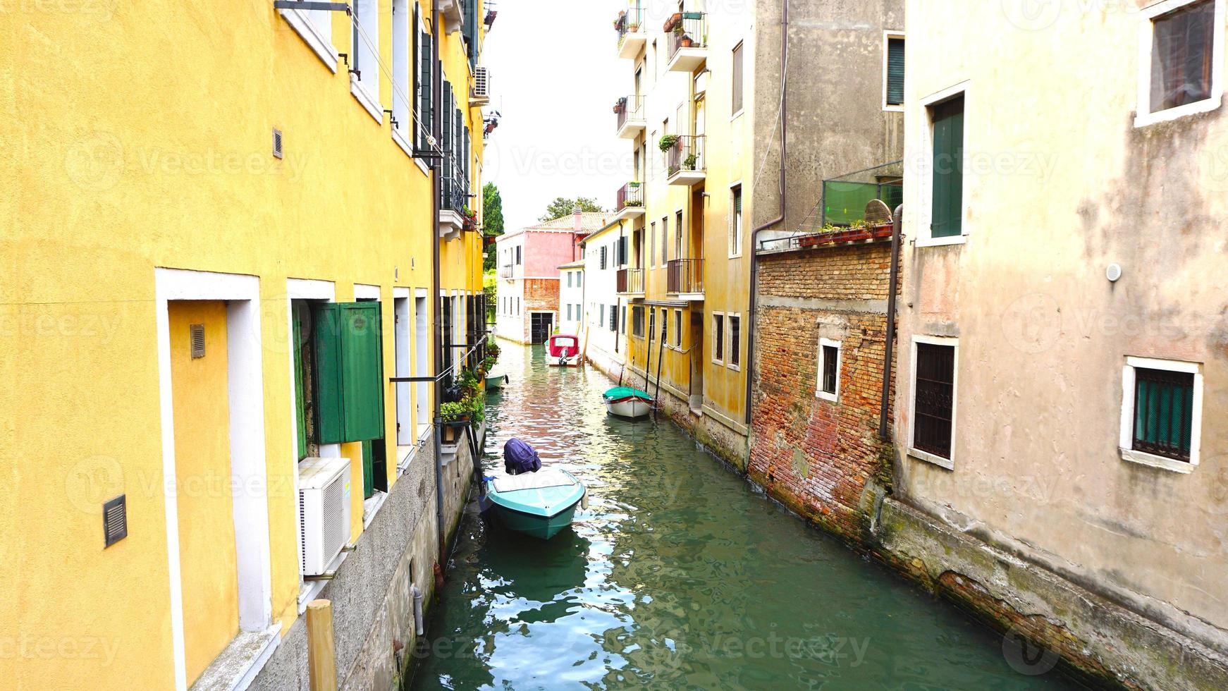 canal and boats with ancient architecture in Venice, Italy photo