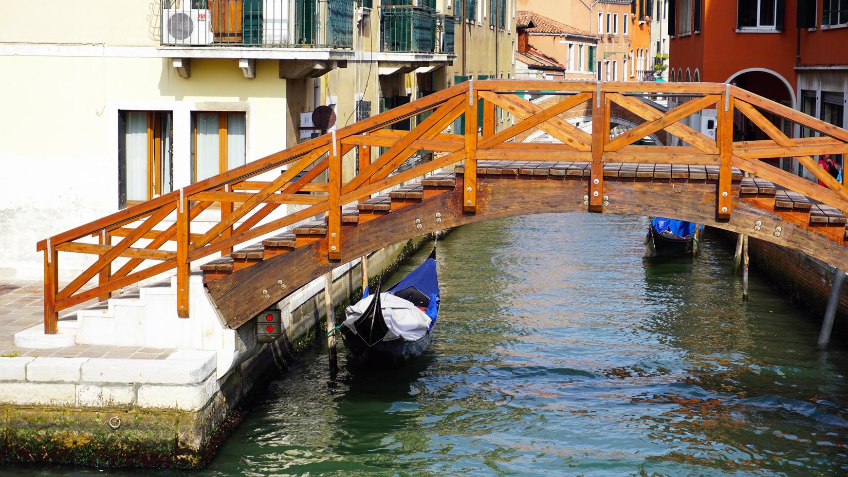 wooden bridge, canal and gondola boat in old town photo