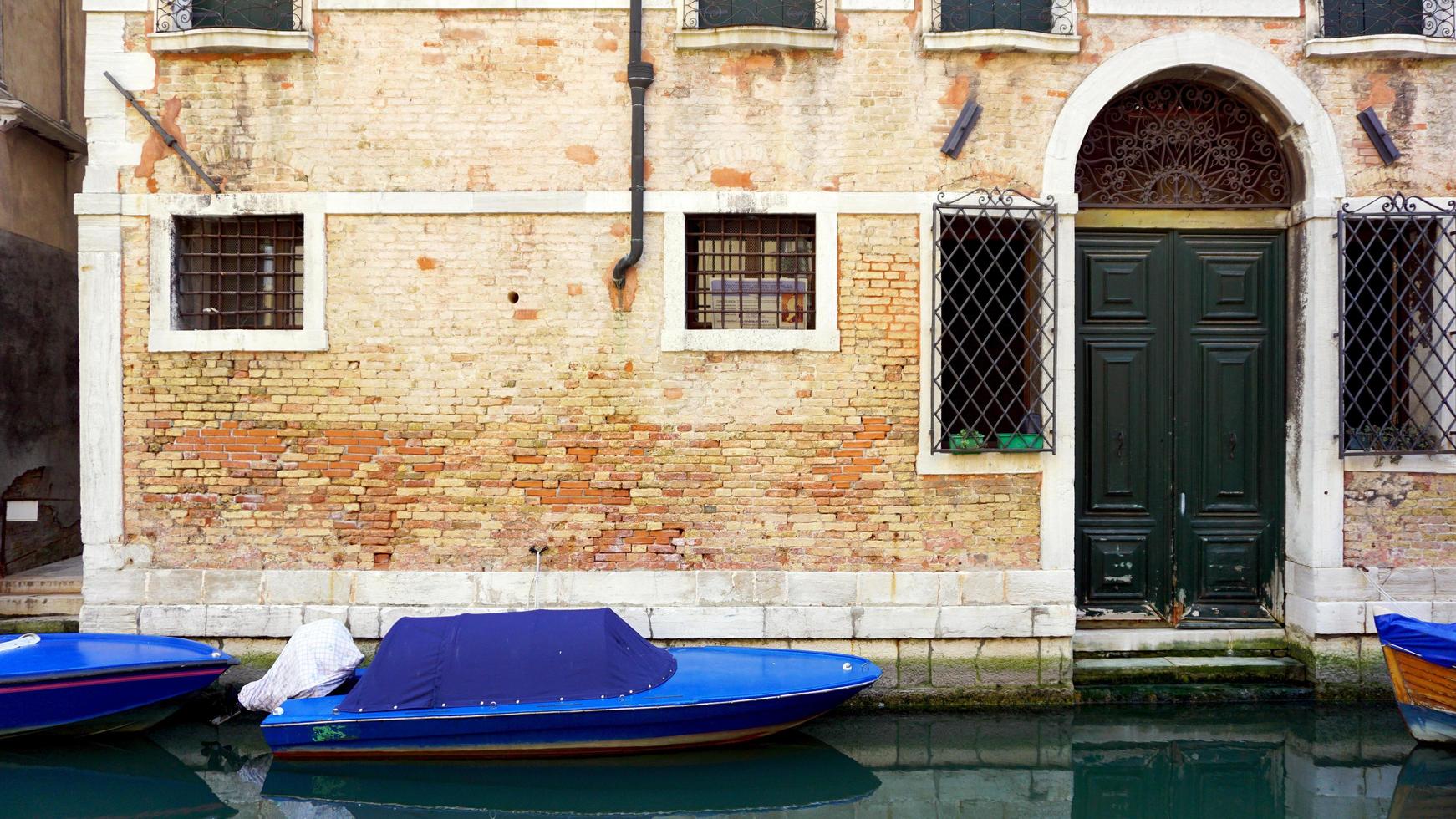 canal and boats with ancient brick wall house photo