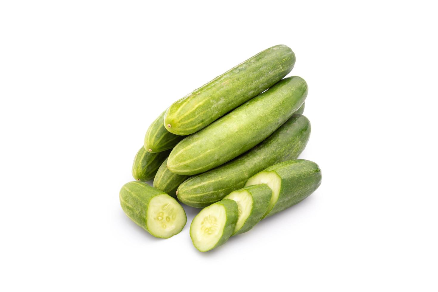 Pile and slice cucumber on wooden table background. Food and healthcare concept photo
