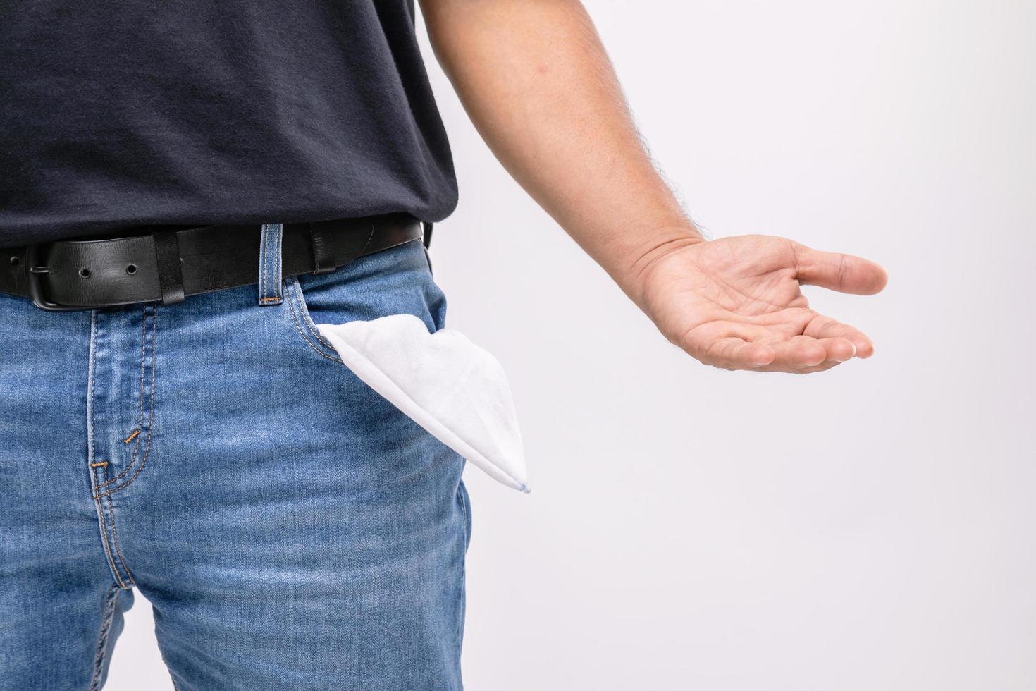 No money in pants pocket. Close up man holding his empty pants pocket to show no money inside. Financial concept photo