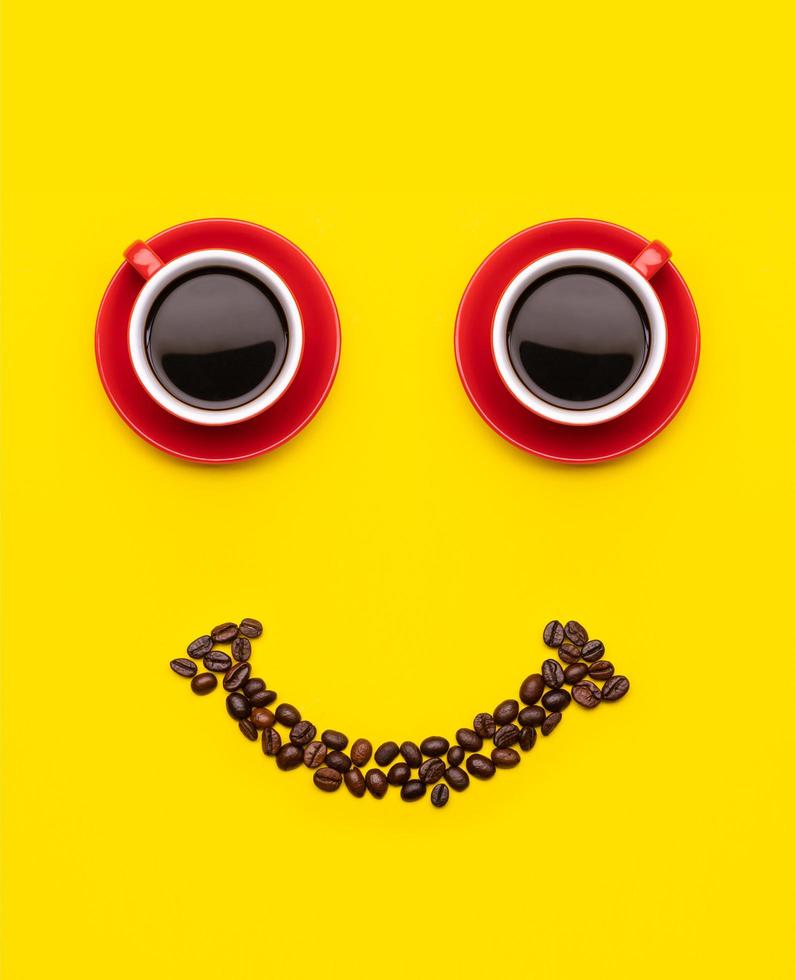Cup of coffee and coffee beans with smile face concept, Top view on yellow background. For morning happy concept photo
