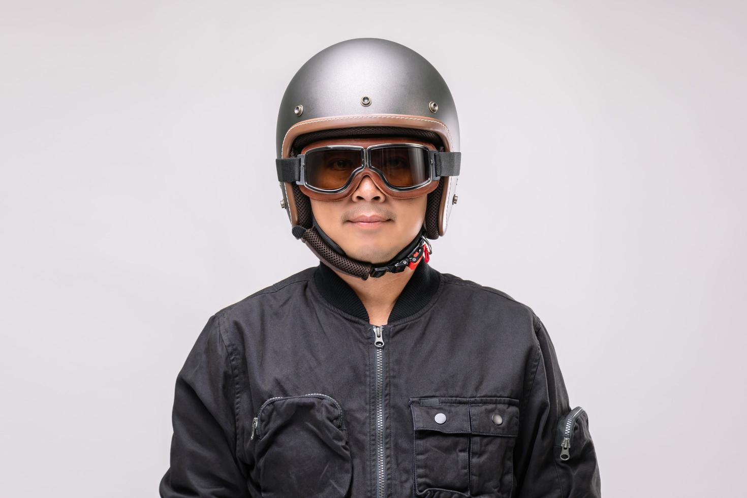 motociclista o jinete con casco antiguo. concepto de viaje seguro. foto de estudio en gris