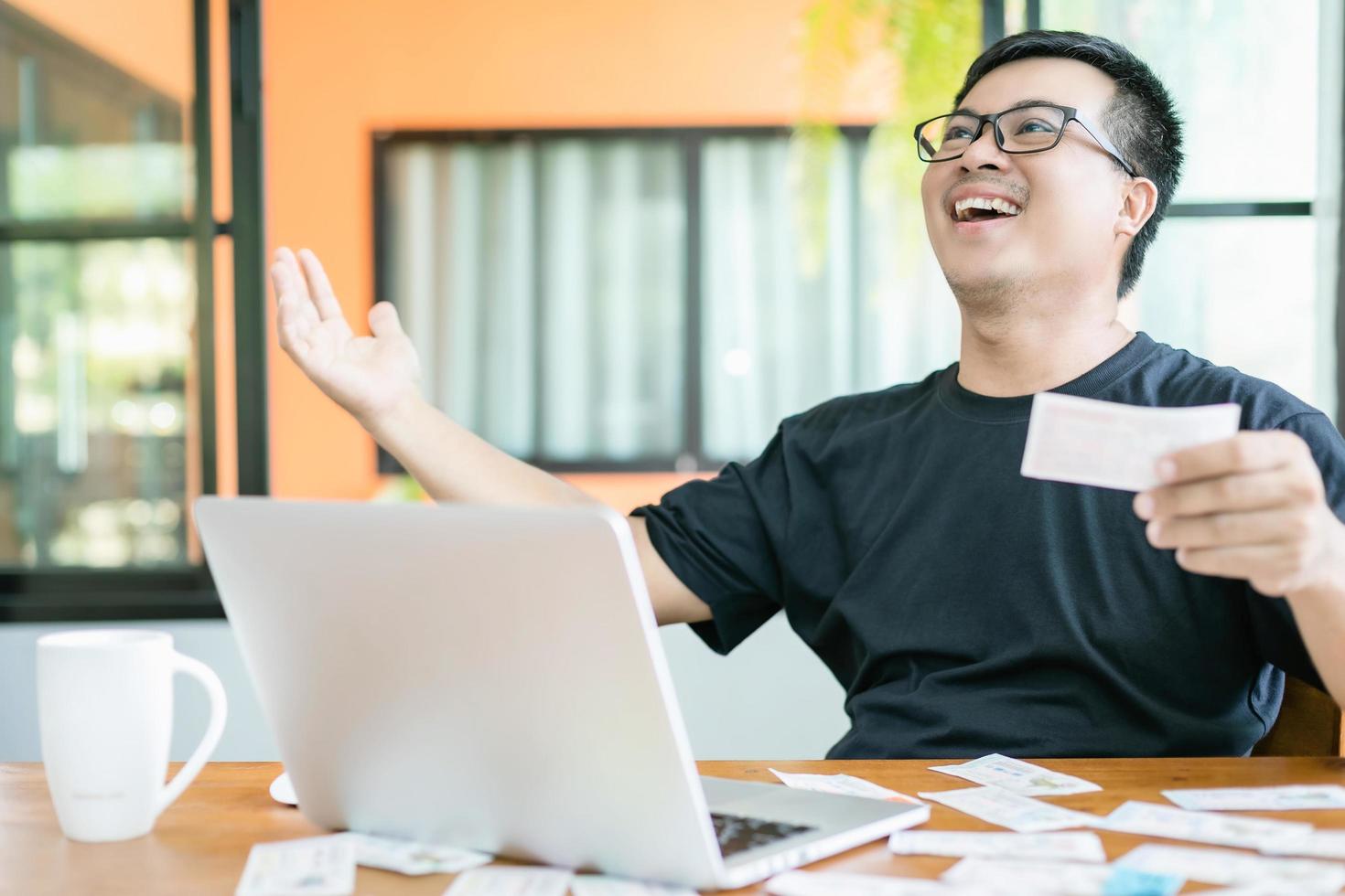 concepto de lotería del gobierno ganador, gente tailandesa revisando el resultado de la lotería del gobierno de tailandia en una computadora portátil y acción muy feliz después de ganar foto