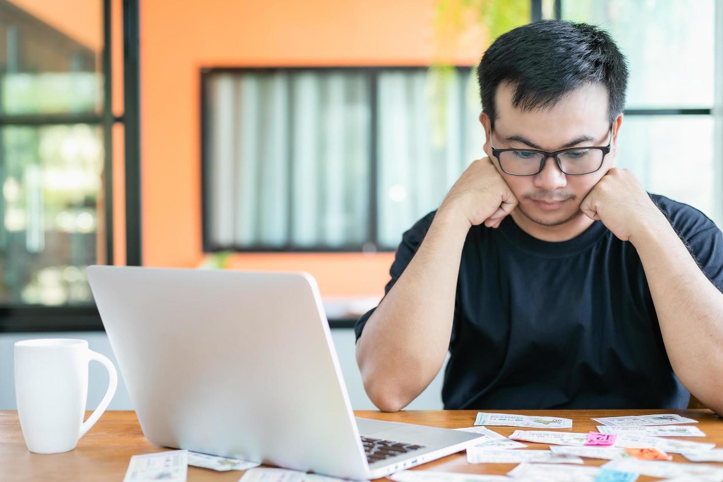 sentirse fracasado por el concepto de lotería del gobierno, los tailandeses revisando el resultado de la lotería del gobierno de Tailandia en una computadora portátil y sintiéndose fracasados o tristes foto