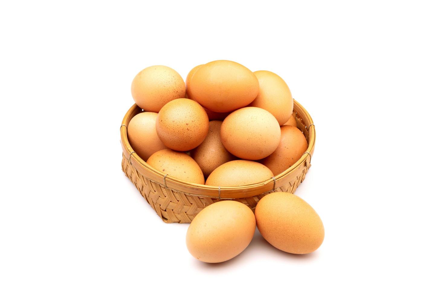 Chicken Eggs in basket isolated on white photo