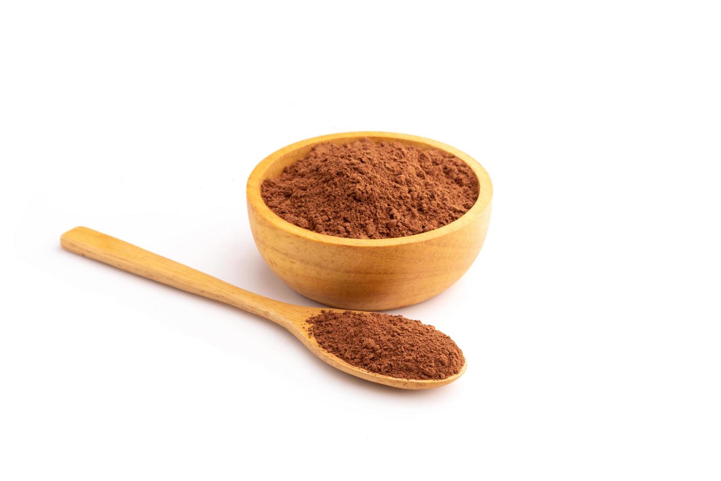 cacao en polvo o chocolate en polvo en un tazón de madera aislado en blanco foto