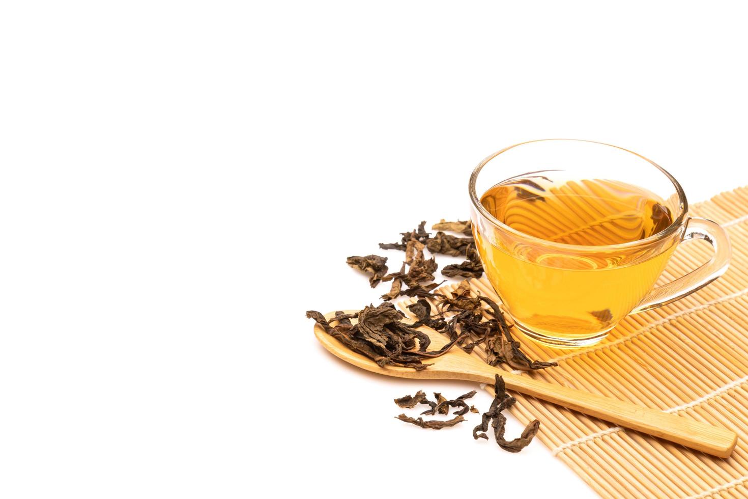 taza de té caliente y hojas de té aisladas en blanco foto