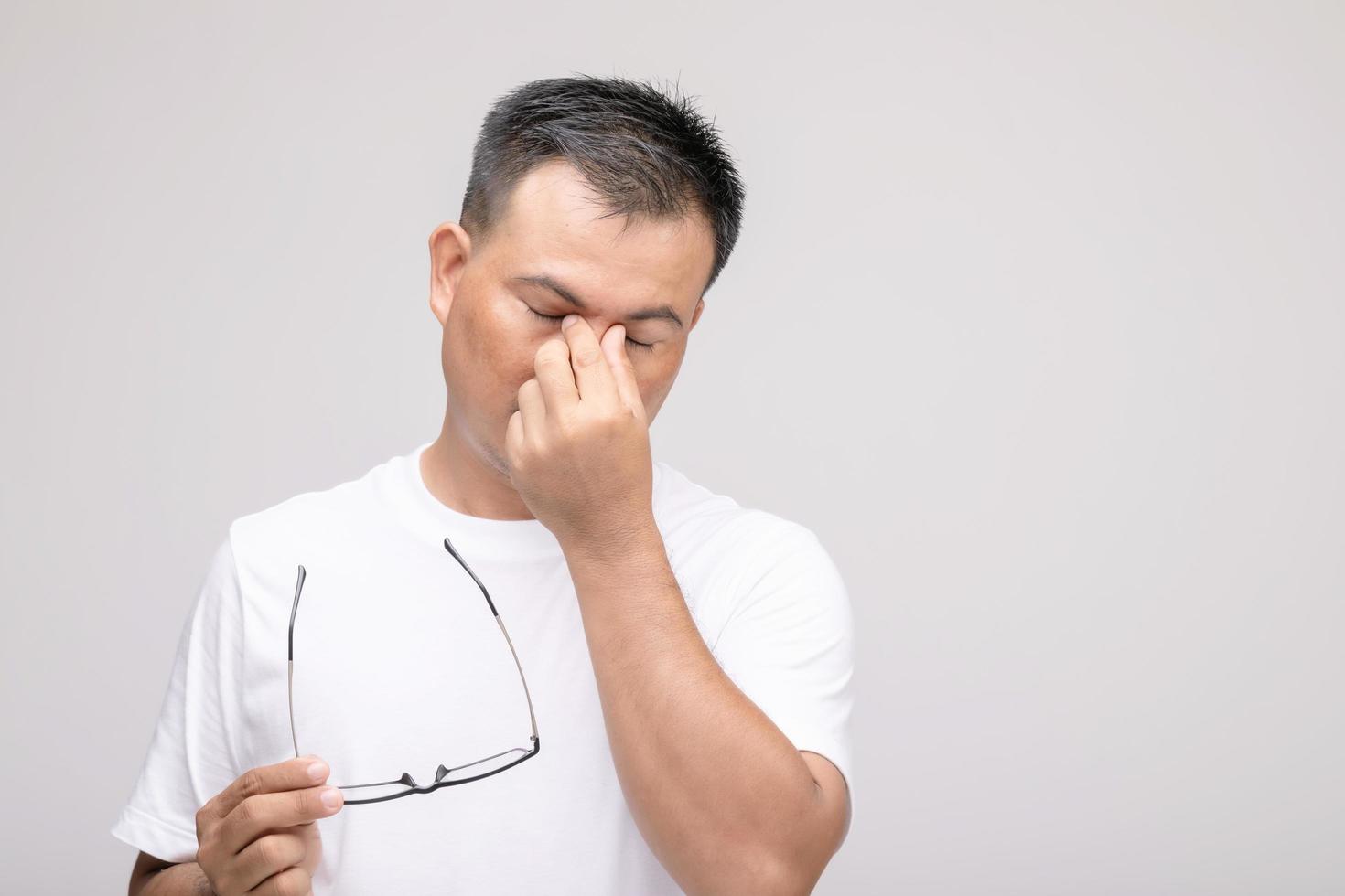 Eye irritation concept, Portrait of Asian man in posture of eye tired,  irritation or problem about his eye. Studio shot isolated on grey photo